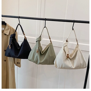 Three pleated shoulder bags in black, green and beige showing soft textured fabric detail