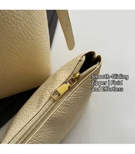 Macro detail of high-quality smooth golden metal zipper on lychee textured shoulder bag
