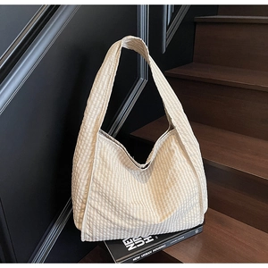 Close-up of beige checkered canvas tote bag texture on a modern staircase setting