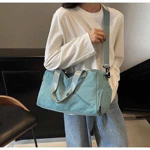 Nylon gym bag shown on model with adjustable strap and spacious side zipper compartment