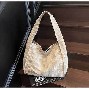 Detail shot of the cream gingham canvas fabric texture on a large hobo shoulder bag