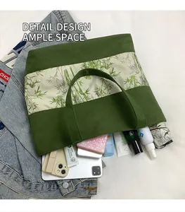 Vue à plat du sac cabas vert en toile montrant sa grande capacité pour tablette et objets
