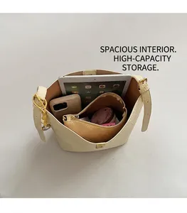 Internal view of beige lychee leather bucket bag showing large capacity and inner pouch
