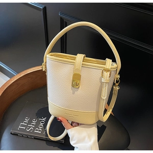 Vue détaillée du sac seau bicolore en cuir grainé avec fermoir rotatif doré brillant