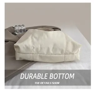 Detail of reinforced wide bottom with double stitching on cream pleated tote bag