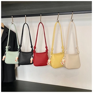 Detail of colorful mini bucket bags with cute space bear charms on thin shoulder straps