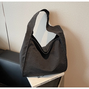 Close-up of the black and white checkered canvas tote bag showing textured fabric detail