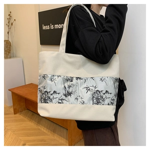 Vue détaillée d'un sac cabas en toile beige avec un imprimé artistique de bambou à l'encre