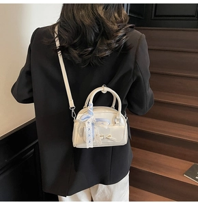 White glossy mini pillow bag with blue plaid ribbon detail on a model's back