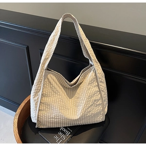 Detailed view of textured beige plaid fabric on a large capacity casual tote shoulder bag