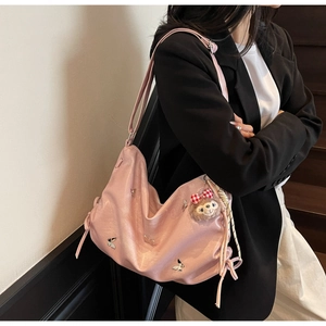 Pink pleated hobo bag with silver butterfly and plush charm shown on model