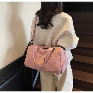 Detail of pink multipurpose travel bag showing shoulder strap and waterproof nylon texture