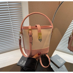 Détail du sac seau rose et crème avec texture grainée et boucle métallique dorée