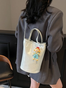 Chic light blue patent leather bucket bag with top handle and fashion doll charm