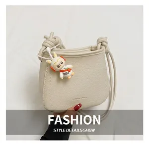 Detail view of cream bucket bag featuring lychee texture and cute astronaut bunny charm