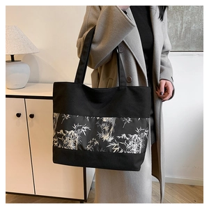 Détail du grand sac cabas noir avec imprimé de bambou blanc pour un look chic