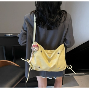 Close-up of light yellow PU leather crossbody bag with silver butterfly embroidery detail