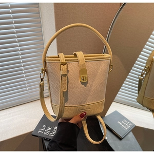Détail du sac seau en cuir grainé avec fermoir doré et poignée supérieure robuste