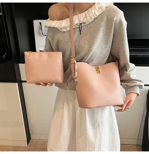 Detailed view of pink pebble leather bucket bag and pouch set with gold-tone hardware