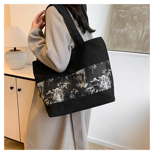 Détail du grand sac cabas en toile noire avec motif de feuilles de bambou blanc