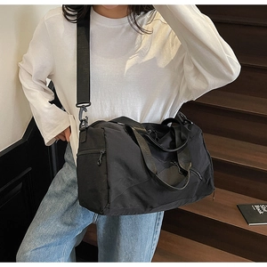 Detail of black large capacity travel bag with durable straps on an urban background