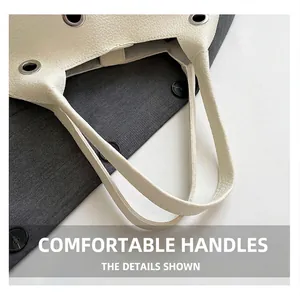 Detail of cream white lychee leather handbag featuring silver grommets and sturdy stitching
