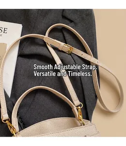 Détail de la bandoulière réglable sur sac en cuir beige grainé avec boucles dorées