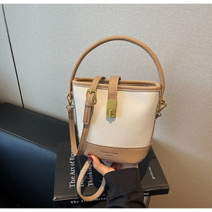 Détail d'un sac seau rétro avec texture litchi et fermeture à boucle carrée en métal doré