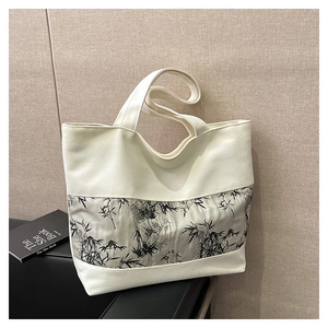 Détail d'un cabas en toile crème avec imprimé bambou à l'encre noire et bandoulière large
