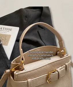 Gros plan sur le sac à main beige grainé avec finitions dorées et boucle de ceinture chic