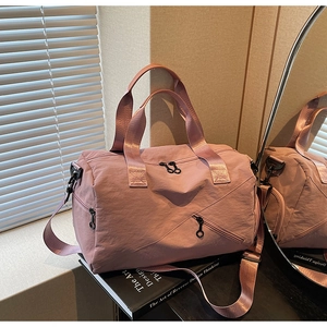 Close-up of pink waterproof nylon gym bag with adjustable straps and zipper pockets