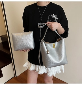 Detail of silver metallic textured bucket bag with gold clasp and matching pouch