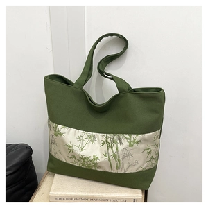 Détail du sac cabas en toile vert foncé avec bande en soie et imprimé de bambou