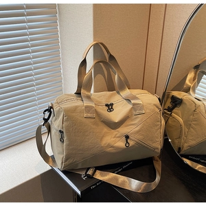 Detail of khaki travel bag with reinforced handles and adjustable metal strap buckle