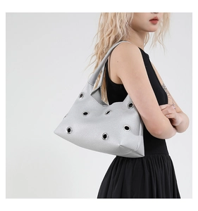 Close-up of silver rivet hollow-out tote bag featuring metallic grommet eyelets detail