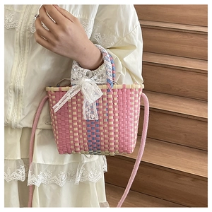 Detailed view of women's woven crossbody bag with pastel colors and lace bow detail