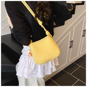 Detail of yellow lychee pattern crossbody bag with a cute rabbit pendant accessory