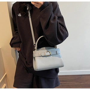 Détail d'un sac à main bleu clair en cuir grainé avec boucle métallique et bandoulière
