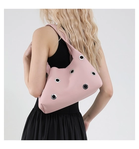 Detailansicht der rosa Schultertasche aus genarbtem Leder mit großen silbernen Ösen