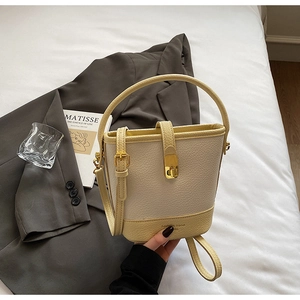 Détail d'un sac seau en cuir grainé avec boucle dorée et bandoulière réglable