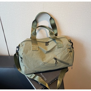 Detail of army green nylon travel bag showing waterproof texture and zipper pockets