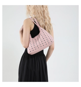 Detail of pink hobo shoulder bag with silver eyelets and pebbled leather texture
