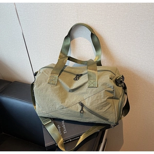 Macro view of olive green travel bag with durable nylon texture and multi-pocket details
