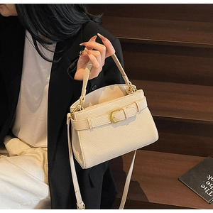 Détail du sac crème texture litchi avec fermoir doré et bandoulière ajustable