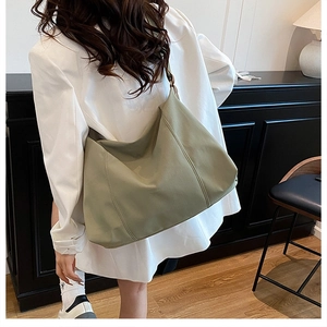 Olive green pleated tote bag shown on model's shoulder highlighting its large capacity