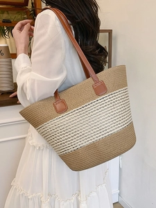 Borsa tote a righe in paglia con manici in pelle marrone indossata da una modella