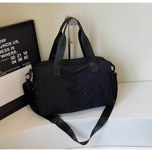 Macro detail of black nylon fitness bag with reinforced handles and removable shoulder strap