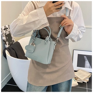Pale blue mini bucket bag in lychee leather with heart charm and slim shoulder strap