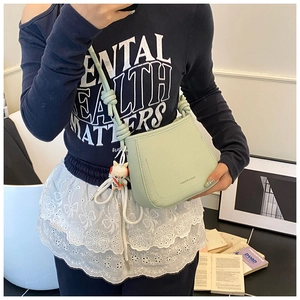 Detail of mint green bucket bag featuring lychee texture and knot shoulder strap