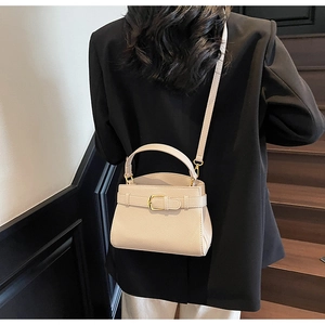 Mini sac beige chic texture litchi porté par un mannequin pour référence de style